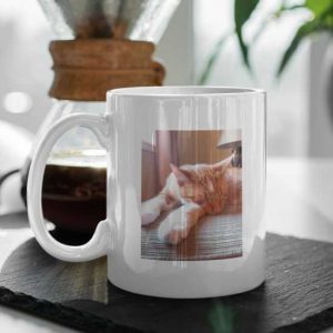 Ceramic mug on table with a picture of cat printed on to it