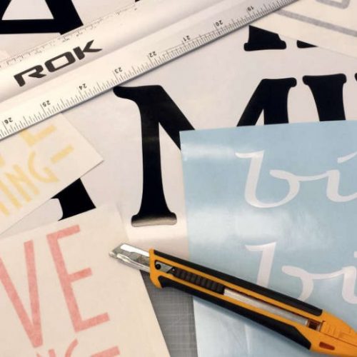 Vinyl lettering shown with knife and ruler on table